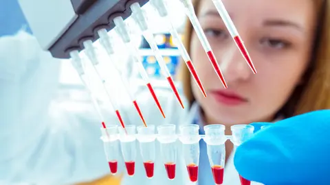 woman assistant in laboratory with multi pipette in the clinic, the research of cancer stem cells
